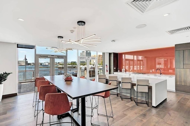dining space featuring visible vents and light wood-style floors
