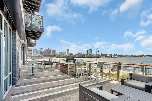 deck with a city view, a water view, and outdoor lounge area