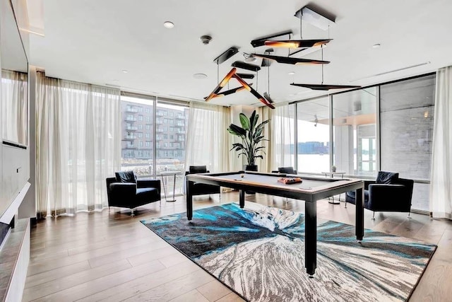 playroom with a healthy amount of sunlight, pool table, floor to ceiling windows, and wood finished floors