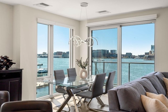 dining space with a view of city, a water view, and visible vents