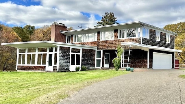 back of property featuring a yard and a garage