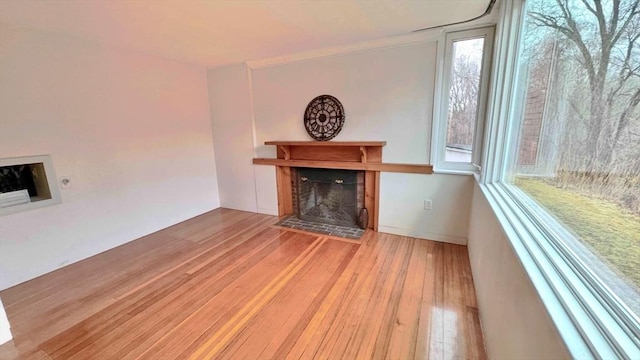 unfurnished living room featuring a tile fireplace and wood-type flooring