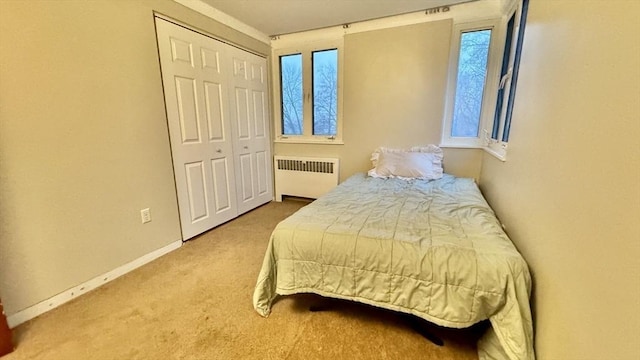 carpeted bedroom featuring a closet and radiator heating unit