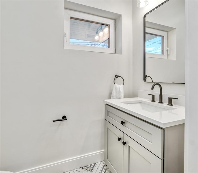 bathroom featuring vanity, a wealth of natural light, and baseboards