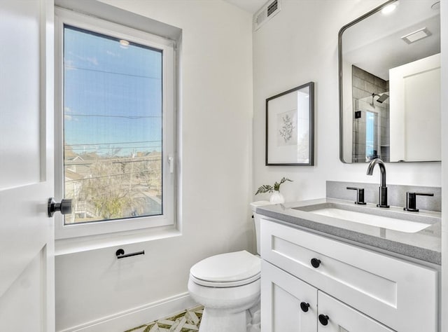 full bath with toilet, visible vents, vanity, baseboards, and a shower