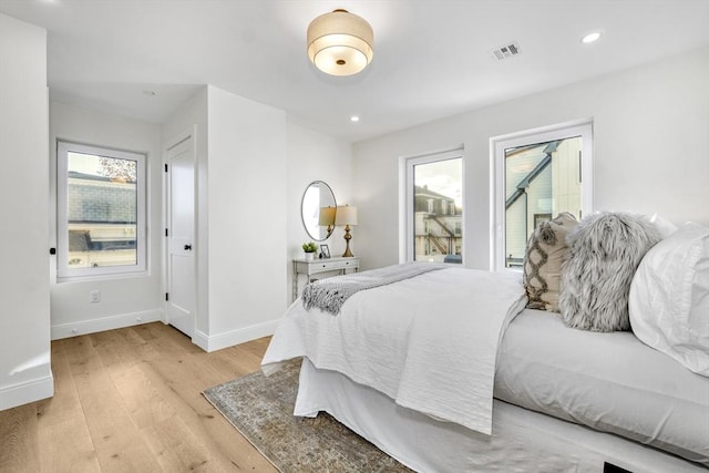 bedroom with recessed lighting, light wood-type flooring, visible vents, and baseboards