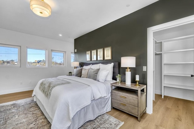 bedroom featuring light wood finished floors and baseboards