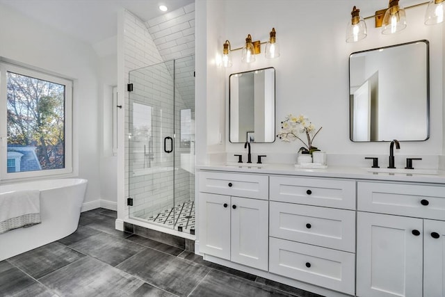 bathroom featuring a stall shower, a sink, a freestanding bath, and double vanity