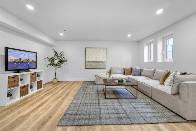 living room featuring baseboards, light wood-style flooring, and recessed lighting