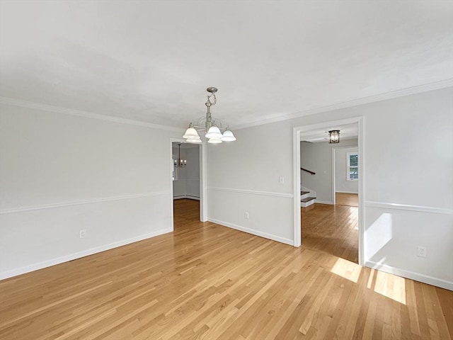 unfurnished dining area with light wood-style flooring, crown molding, a notable chandelier, and stairs