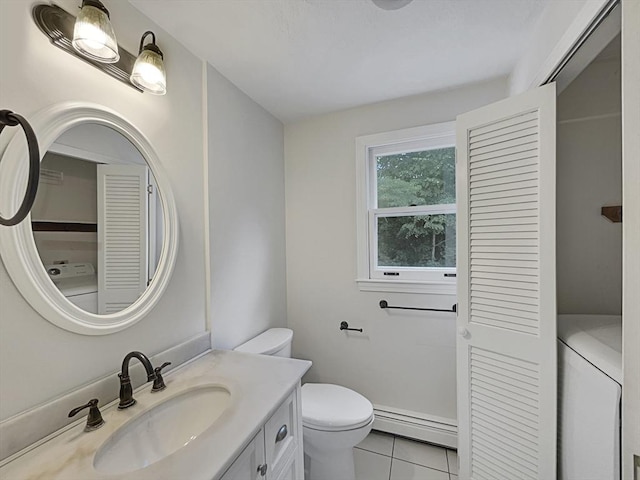 bathroom with a closet, washer / clothes dryer, toilet, a baseboard heating unit, and vanity