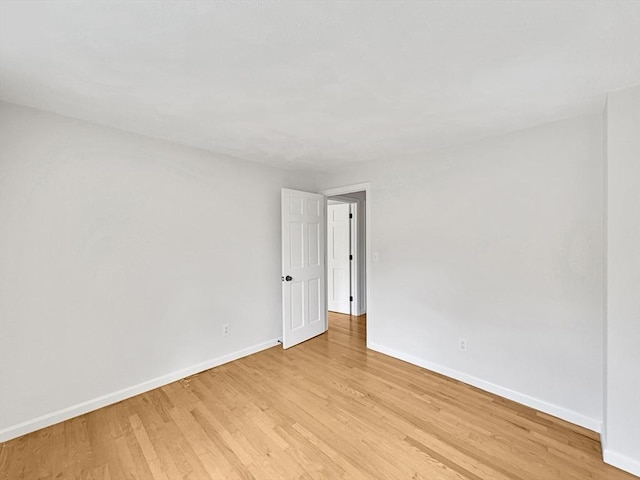 empty room with light wood-style flooring and baseboards