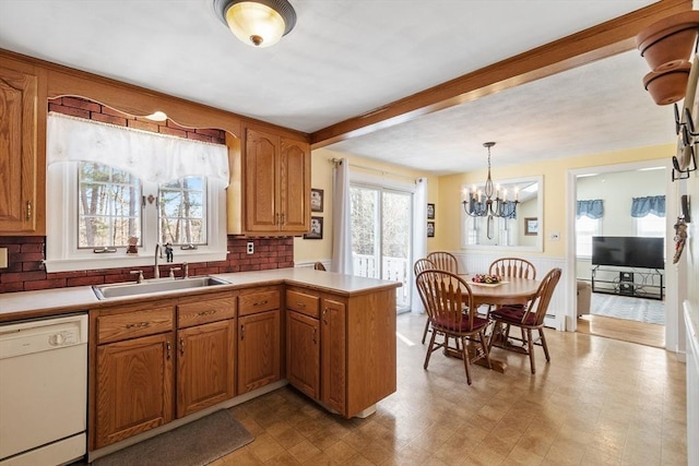 kitchen with plenty of natural light, light countertops, dishwasher, and a sink