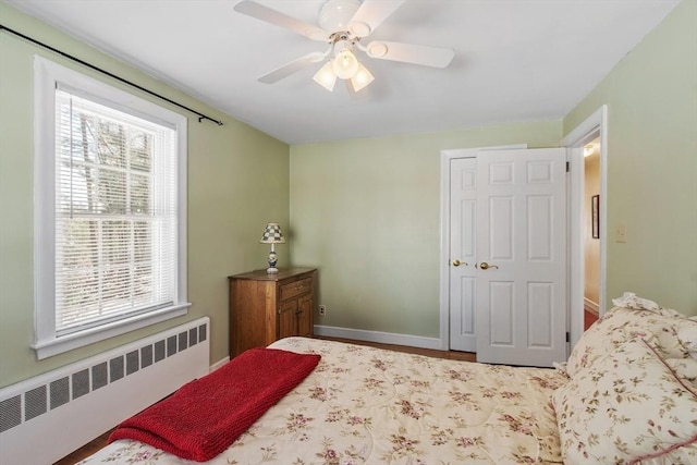 bedroom with baseboards, ceiling fan, and radiator heating unit