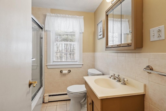 bathroom featuring tile walls, toilet, a baseboard heating unit, vanity, and tile patterned flooring