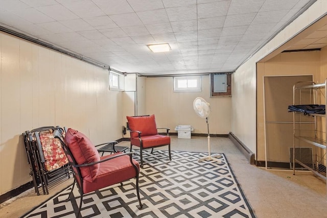 living area with electric panel, baseboards, and tile patterned floors