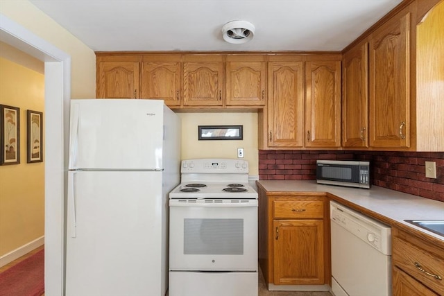 kitchen featuring light countertops, white appliances, backsplash, and brown cabinets