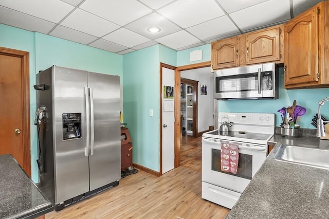 16 Boyce St, Worcester, MA 01603 - kitchen with appliances with stainless steel finishes, dark countertops, light wood-style flooring, a paneled ceiling, and brown cabinetry