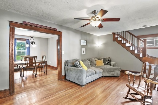 16 Boyce St, Worcester, MA 01603 - living room with light wood-style flooring, ceiling fan, stairway, a chandelier, and a textured ceiling