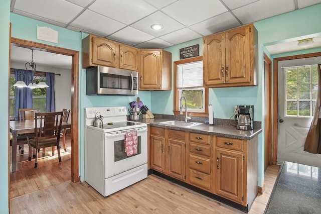 16 Boyce St, Worcester, MA 01603 - kitchen with white electric stove, stainless steel microwave, dark countertops, light wood-style floors, and brown cabinets