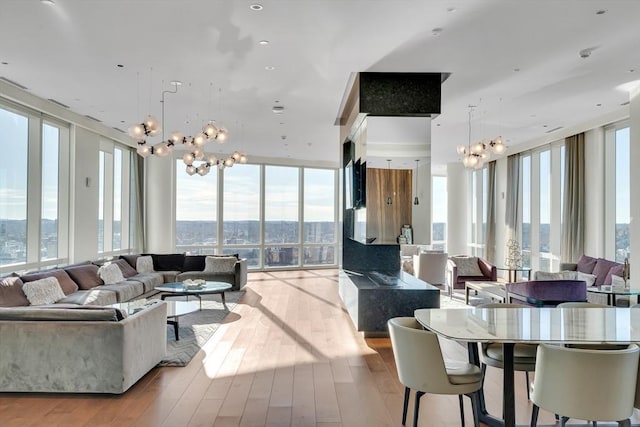 living room featuring light hardwood / wood-style flooring, floor to ceiling windows, and a chandelier