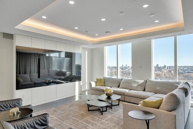 living room with a wall of windows and a raised ceiling