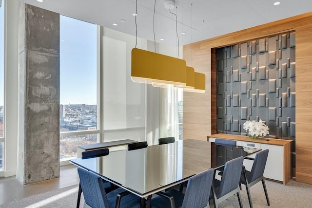 dining room with expansive windows and wooden walls