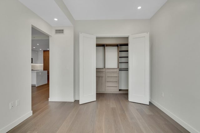 unfurnished bedroom featuring a closet and light wood-type flooring