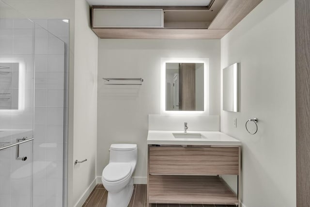 bathroom with a shower with door, vanity, and toilet