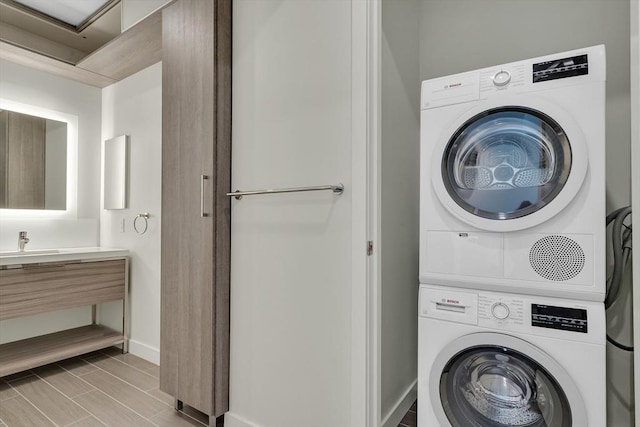 laundry room with stacked washer / dryer and sink