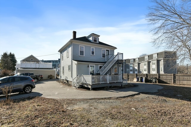 rear view of property with a deck and a garage