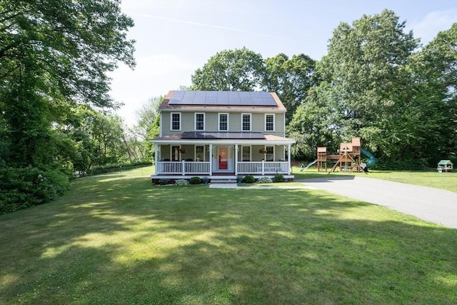 15 Rose Ln, Uxbridge, MA 01569 - view of front facade with covered porch, solar panels, a front yard, and a playground