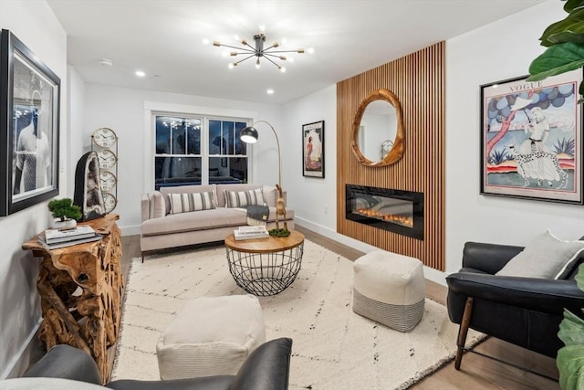 living area featuring wood finished floors, recessed lighting, a fireplace, baseboards, and a chandelier