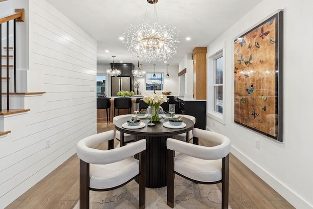 dining room with baseboards, a chandelier, stairs, recessed lighting, and wood finished floors