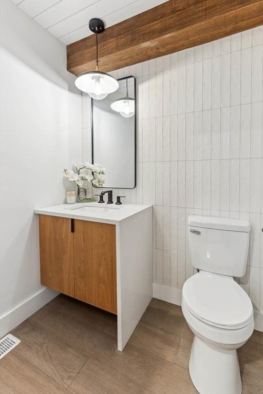 bathroom featuring visible vents, baseboards, toilet, and vanity