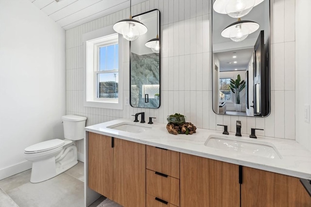 bathroom featuring tile patterned floors, double vanity, toilet, and a sink