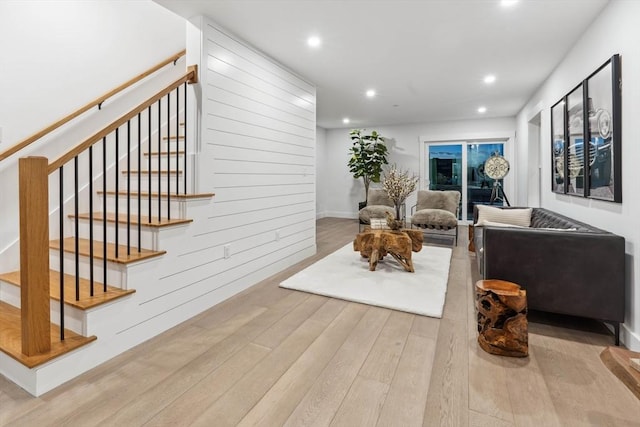 living room with stairs, recessed lighting, and wood-type flooring