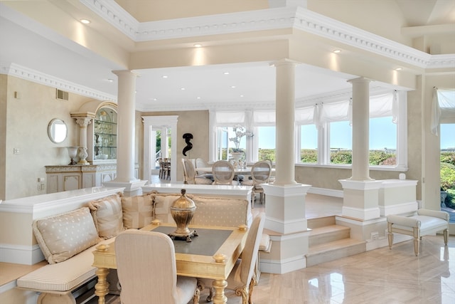 dining area featuring decorative columns, ornamental molding, a towering ceiling, and a wealth of natural light