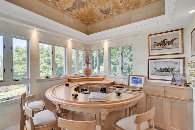 dining room featuring ornamental molding, a tray ceiling, and a healthy amount of sunlight