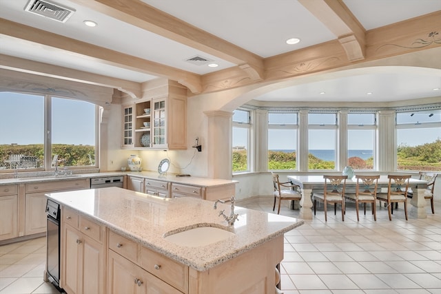 kitchen featuring a wealth of natural light, a kitchen island with sink, and sink