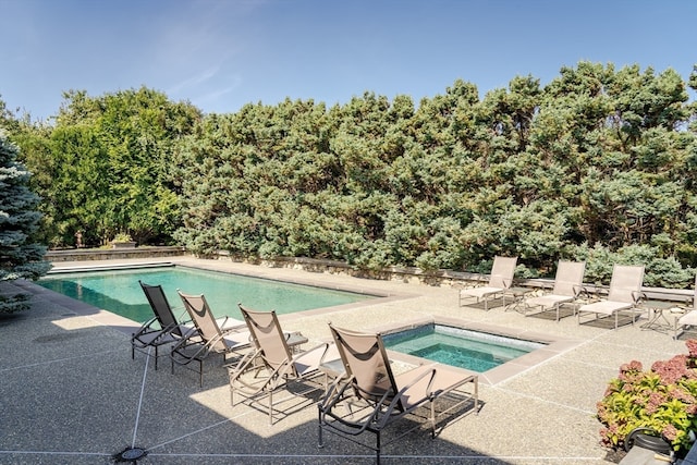 view of pool with an in ground hot tub and a patio area