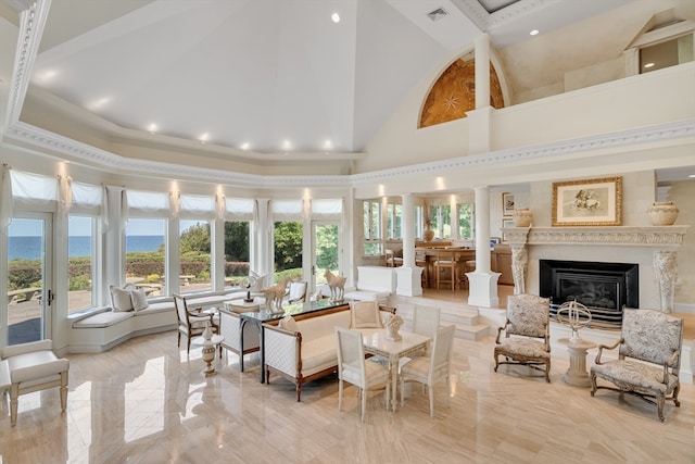 living room with ornamental molding, a high ceiling, and a wealth of natural light