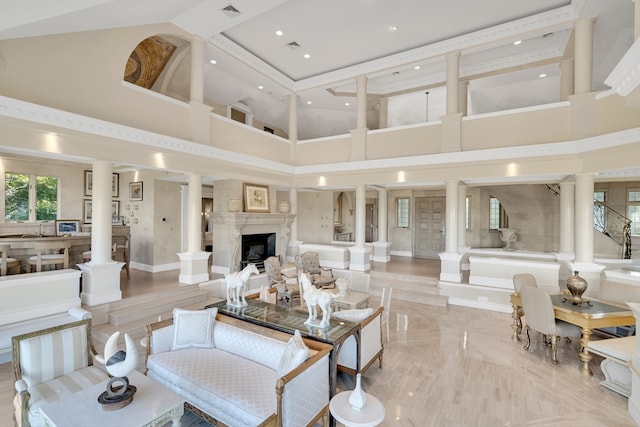 living room featuring high vaulted ceiling, a premium fireplace, and ornate columns