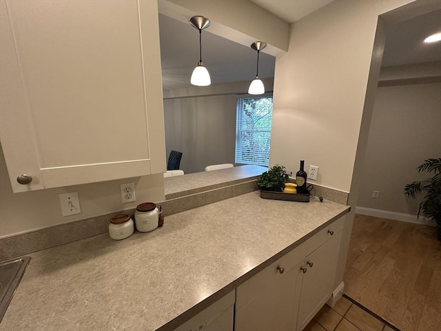 1 Loring Ave Unit 206, Swampscott, MA 01907 - kitchen with white cabinetry, decorative light fixtures, light countertops, and baseboards