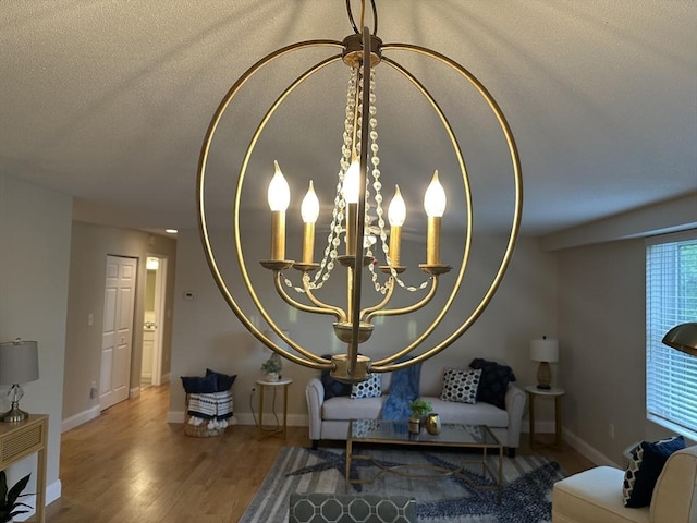 1 Loring Ave Unit 206, Swampscott, MA 01907 - living area featuring wood finished floors, a chandelier, a textured ceiling, and baseboards