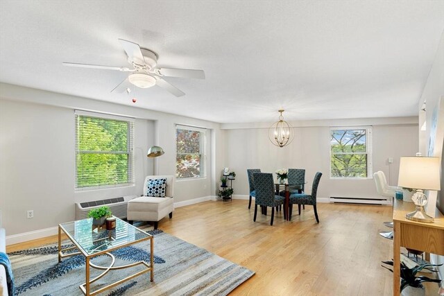 1 Loring Ave Unit 206, Swampscott, MA 01907 - living area with baseboard heating, a chandelier, light wood-style floors, ceiling fan, and baseboards