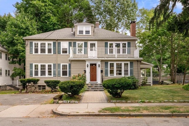 view of front of home featuring a balcony and a front yard