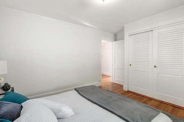 bedroom featuring ornamental molding, hardwood / wood-style flooring, and a closet