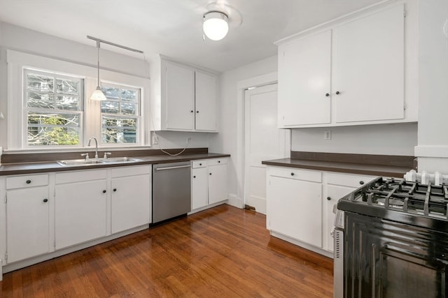 kitchen with decorative light fixtures, appliances with stainless steel finishes, sink, white cabinetry, and hardwood / wood-style flooring