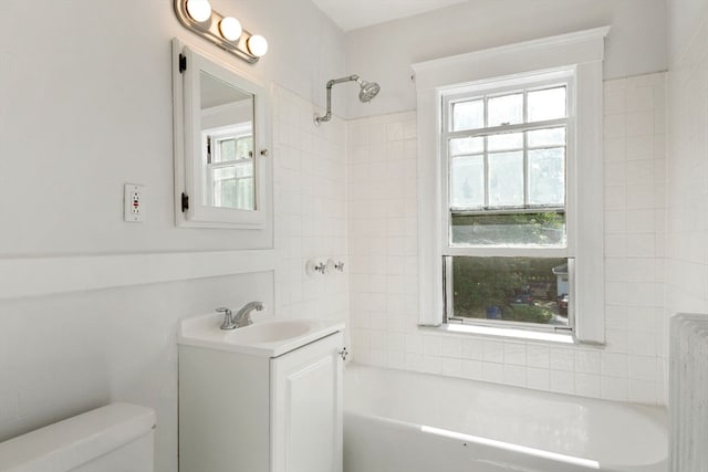 full bathroom featuring vanity, toilet, tiled shower / bath combo, and radiator heating unit